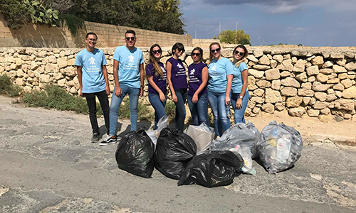 A team of Grant Thornton employees posing with garbage bags at the end of the cleaning day