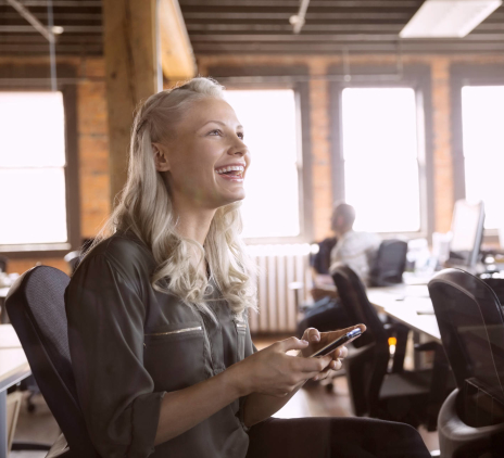 a laughing woman at her desk