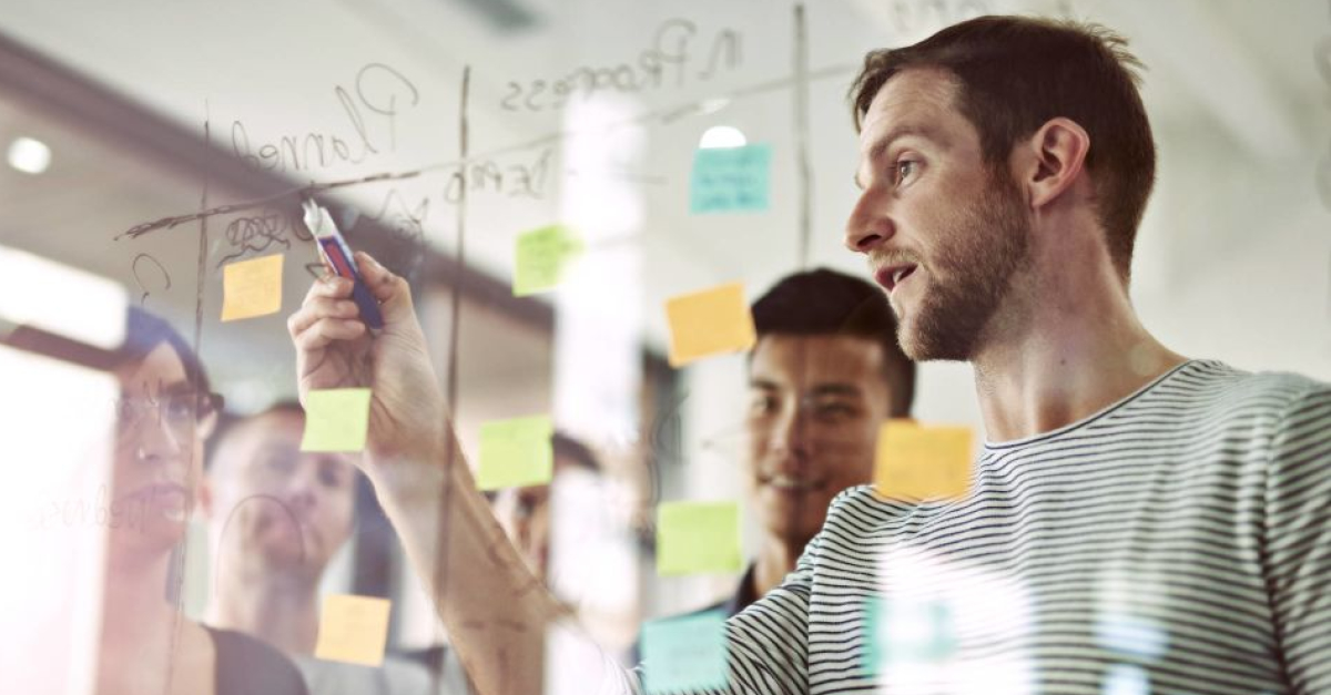 A man explain something on a transparent board