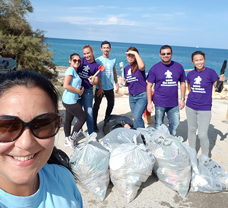 A team of Grant Thornton employees posing with garbage bags at the end of the cleaning day