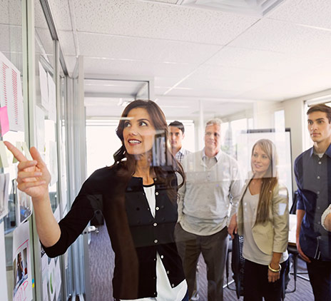 A woman explains something on the board in front of other people.