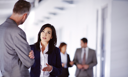 A businesswoman and a businessman talk together