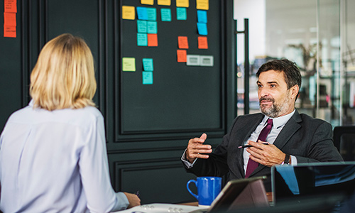 A businessman talks with a businesswoman