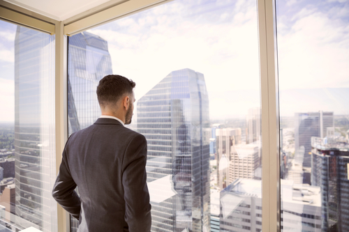 A man looks out the window of a building