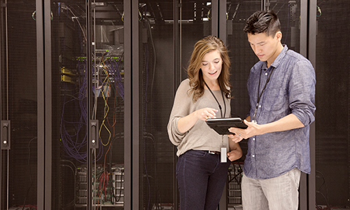 Business people using tablet computer in server room